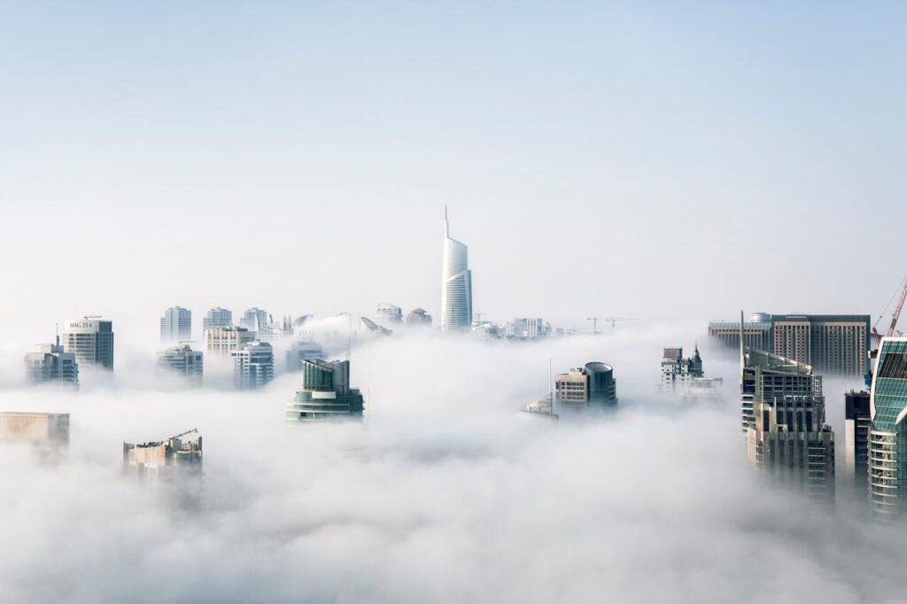 A stunning view of Dubai skyscrapers emerging through a blanket of fog, showcasing modern architecture.